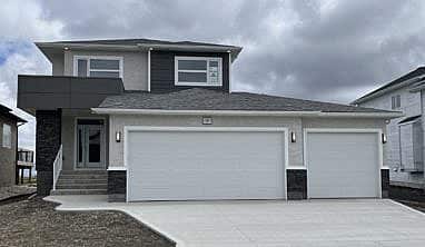 New built two-storey home with triple-car attached garage.
